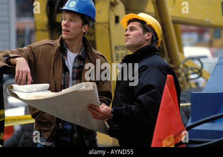 Cuisinier, chef de race blanche portant des casques de l'examen de plans sur un site de construction Banque D'Images
