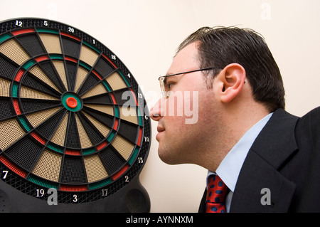 Portrait of a middle aged man wearing suit à la cible à fléchettes Banque D'Images