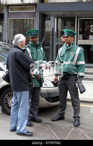 Conducteur de véhicule arguant avec deux Parking Londres Oficers les gardes de trafic de contrôle Banque D'Images