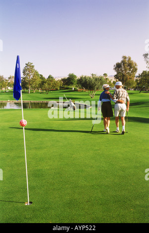 Vieux couple laissant golf green en Californie dans les bras Banque D'Images