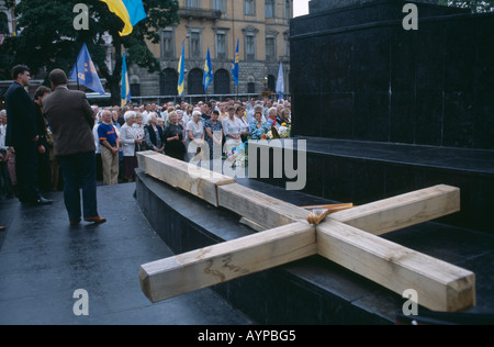 UKRAINE Asie centrale Lvov Grande croix de bois repose à plat en face de foule dédié aux victimes du goulag camp de travail forcé de Lviv Banque D'Images