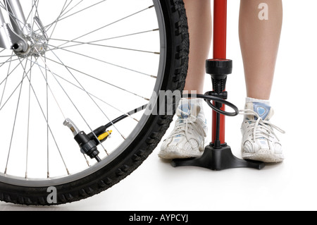 Jeune femme du gonflage des pneus de vélo Banque D'Images