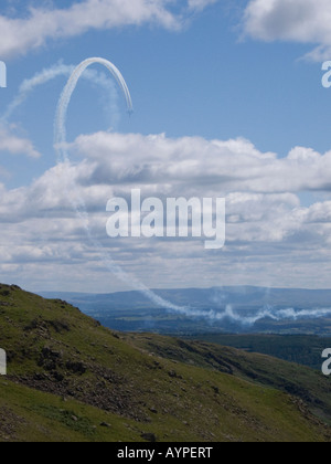 Traînée de vapeur en boucle à partir de l'exécution de l'équipe des flèches rouges sur Windermere dans le Lake District, UK Banque D'Images