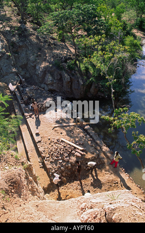 Les ouvriers bloquant un ravin étroit pour former un nouveau petit barrage, pour fournir de l'eau à trois villages à proximité. Nr. Binga, Zimbabwe Banque D'Images