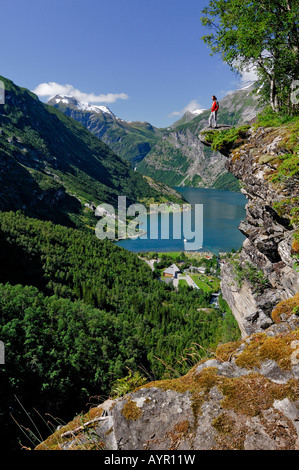 Homme debout sur un rocher Pulpit au fjord de Geiranger, Hellesylt, More og Romsdal (Norvège) Banque D'Images