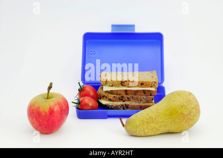 Boîtier plat bleu rempli de sandwiches et des tomates, des fruits en premier plan Banque D'Images