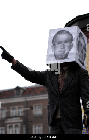 Manifestation anti-guerre à Poznan, en Pologne, avec un manifestant portant une boîte représentant le visage de George W. Bush tout en pointant une main gantée. Banque D'Images