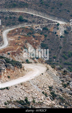 Vue en angle élevé d'une route sinueuse pittoresque serpentant à travers les montagnes près de Benalmadena, Andalousie, Espagne. Chemin de terre sinueux sur une colline rocheuse. Banque D'Images