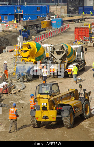 Travailleurs de la construction Hard Hat & High vis veste nouveau logement développement chantier béton ciment mélangeur livraison camion & chariot élévateur Londres UK Banque D'Images