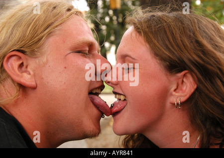 Gros plan de jeunes goths s'embrassant avec des piercings à la langue lors du Castle Party Music Festival à Bolkow, en Pologne. Banque D'Images