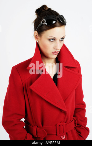 Young woman wearing red coat, collier et lunettes à la grave Banque D'Images
