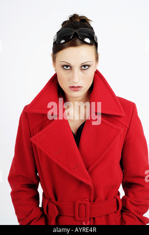 Young woman wearing red coat et lunettes à la grave Banque D'Images