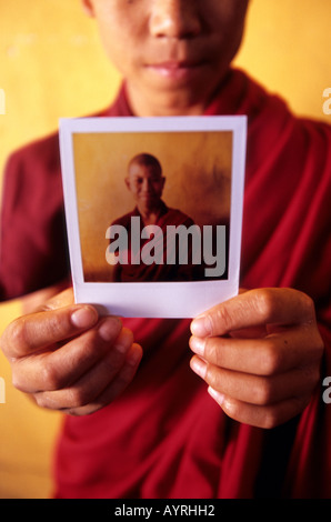 Portrait d'un jeune moine montrant un Polaroid de lui, le Bhoutan Banque D'Images