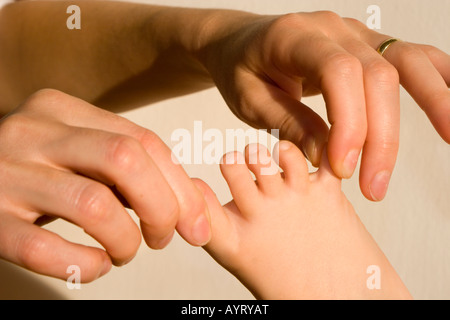 Woman's hands tire sur les orteils de l'enfant Banque D'Images