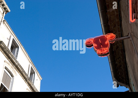 À la recherche d'une enseigne au néon rouge tête de vaches à l'extérieur d'une boutique de bouchers à Montpellier france Banque D'Images