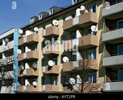 Des antennes paraboliques montées sur les balcons d'un immeuble à appartements Banque D'Images