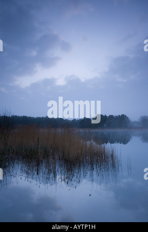 L'aube s'allume le dessous des nuages sur un matin de printemps (2008) à Frensham Little Pond, Farnham, Surrey. Banque D'Images