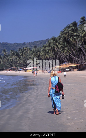 GOA, Inde. Une jeune femme marchant le long de plage de Palolem dans le sud de Goa. Banque D'Images