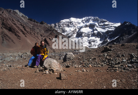 Randonneurs assis sur le rocher face à l'avant dans la vallée de Lower Horcones en route pour Plaza Francia, face sud du mont. Aconcagua en arrière-plan, Argentine Banque D'Images