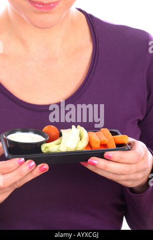 Young Woman Eating crudités avec une trempette Parution Modèle Banque D'Images