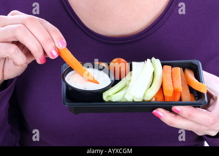 Young Woman Eating crudités avec une trempette Parution Modèle Banque D'Images