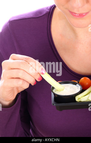 Young Woman Eating crudités avec une trempette Parution Modèle Banque D'Images