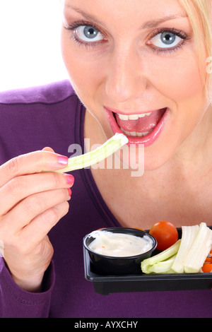 Young Woman Eating crudités avec une trempette Parution Modèle Banque D'Images