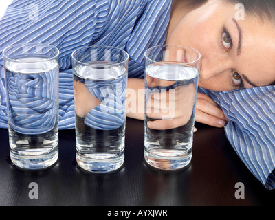 Jeune femme avec des verres de l'eau Parution du modèle Banque D'Images