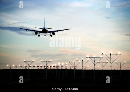 Un format paysage image d'un avion de passagers commerciaux en approche finale à la terre avec feux de piste menant à l'image. Banque D'Images