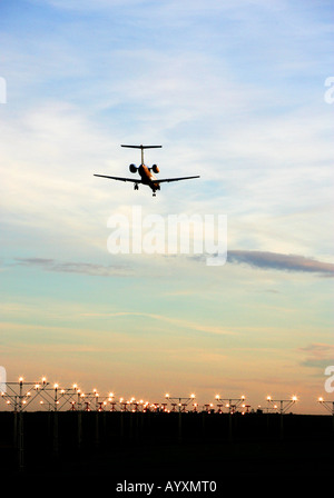 Un portrait format image d'un avion de passagers commerciaux en approche finale à la terre avec feux de piste menant à l'image. Banque D'Images