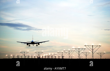 Un format paysage image d'un avion de passagers commerciaux en approche finale à la terre avec feux de piste menant à l'image. Banque D'Images