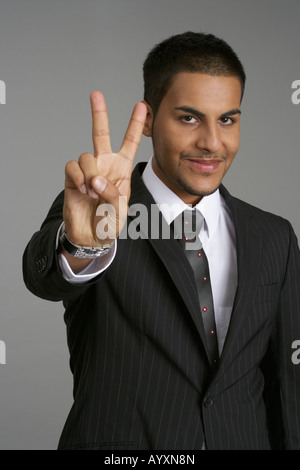Businessman making peace sign Banque D'Images