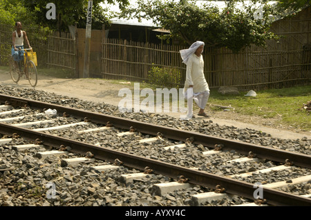 Un vieil homme indien vêtu de vêtements blancs marchant à côté de la piste des chemins de fer indiens dans l'Inde rurale, en Asie. Banque D'Images
