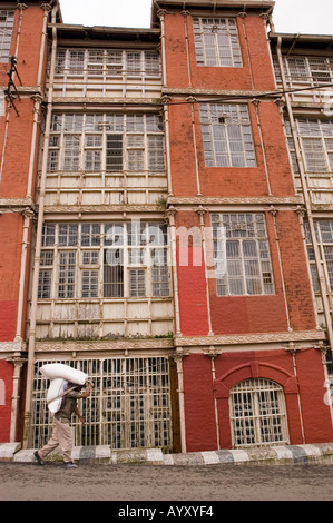 Un portier indien transportant une charge lourde en face de Shimla heritage période britannique Bâtiment Conseil fer 189697 Himachal Pradesh Banque D'Images