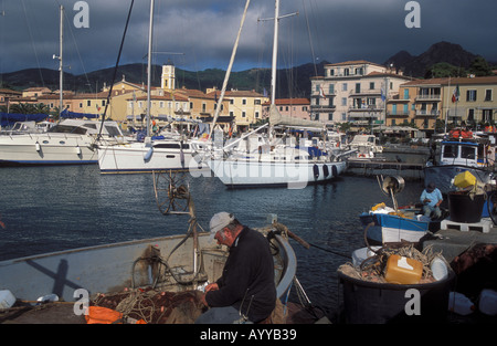 Porto Azzurro les pêcheurs du port de l'île Elba Italie filets de réparation Banque D'Images