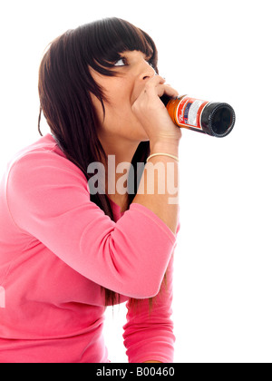 Jeune Adolescente mineurs assis sur le sol face à lui seul causé l'abus d'alcool Boire de l'alcool porte un haut rose et bleu denim Jeans Banque D'Images