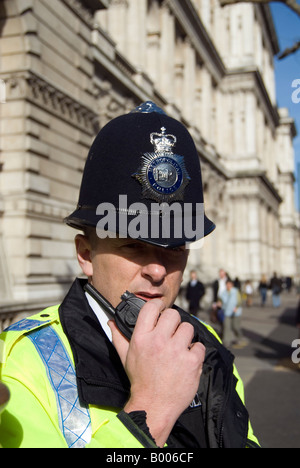 Policier en conversation sur talkie walkie London England UK Banque D'Images