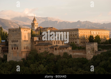 Le soleil couchant jette une lueur orange sur les montagnes de la Sierra Nevada et le palais de l'Alhambra à Grenade Espagne Banque D'Images