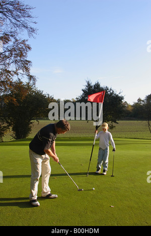 Golf green putt boy avec drapeau Banque D'Images