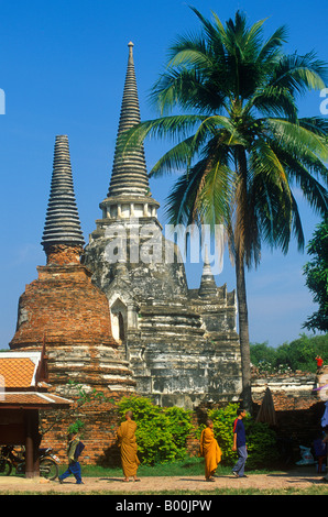 Moines en face d'un ancien Chedi dans les ruines du Wat Phra Si Sanphet à Ayutthaya en Thaïlande Banque D'Images