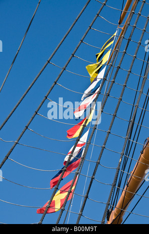 Drapeaux du signal du mât d'un voilier, contre le ciel bleu Banque D'Images