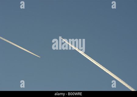 Avion dans le ciel avec des traînées de vapeur Banque D'Images