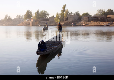 Mali, Mopti. Une pirogue agit comme un ferry pour le transport de personnes dans un affluent du fleuve Niger à Mopti. Banque D'Images