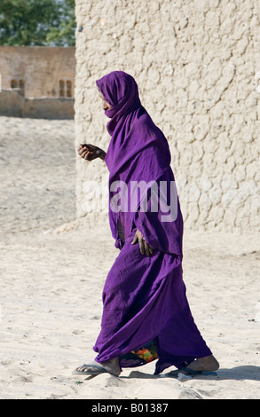 Mali, Tombouctou. Une vieille femme marche dans les rues sablonneuses de Tombouctou. Banque D'Images