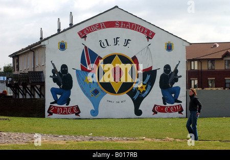 Une femme passe devant une peinture murale loyalistes protestants à Belfast. Banque D'Images