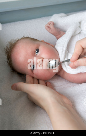 Bébé reçoit des vitamines avec une cuillère Banque D'Images