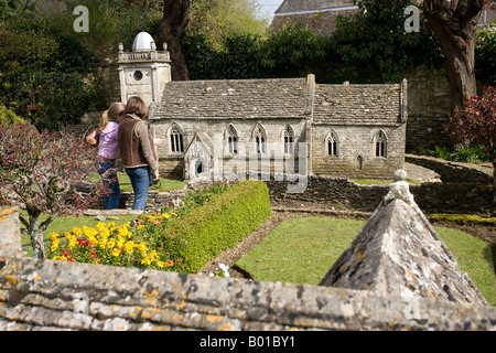 Les visiteurs admirant miniature de St Lawrences church village modèle Kingham Cotswolds UK Banque D'Images