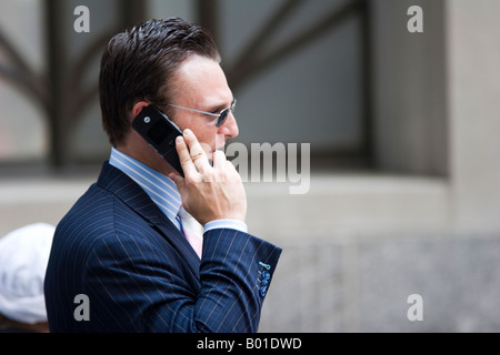 Un homme parle sur un téléphone cellulaire nouveau Wall Street à New York City, New York, USA Banque D'Images