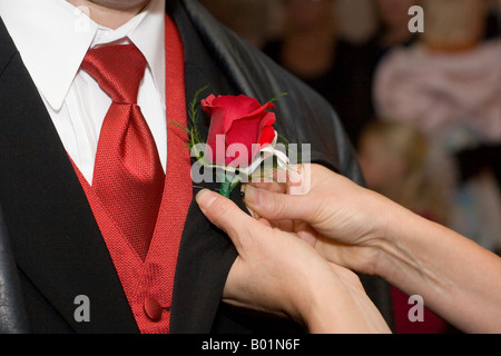 Les axes d'une femme une rose sur un revers de l'homme à un mariage. Banque D'Images