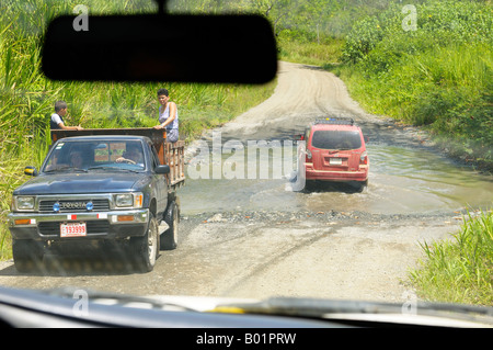 Des taxis à gué d'un ruisseau sur le karaté à Puerto Jimenez road au Costa Rica Banque D'Images